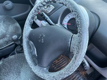 Car interior with frost covering the steering wheel and seats.