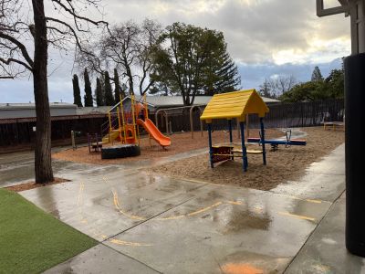 Empty playground with slides and swings on a cloudy day.