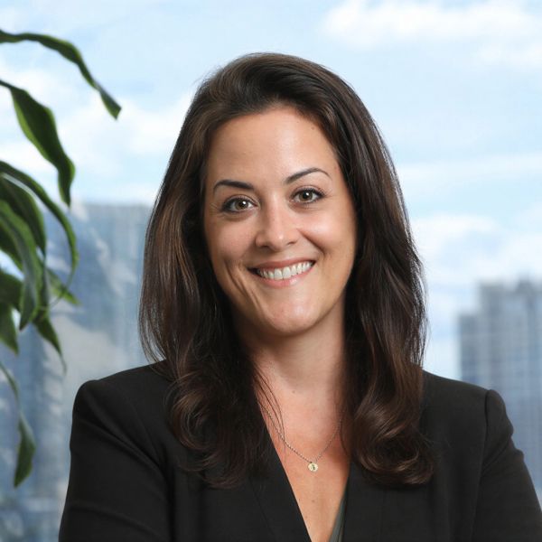 Woman smiling confidently against an urban background.