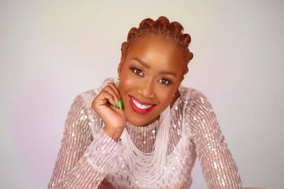a picture of a woman smiling with her head resting on her hand