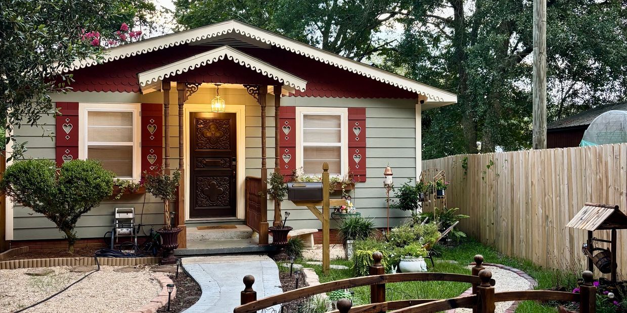 Cozy cottage with charming heart-decorated red shutters.
