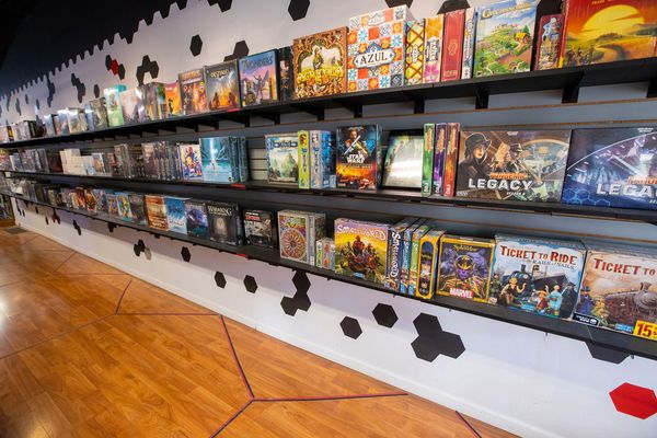 Critical Hit Games main board game wall. Retail shelves covered in board games.