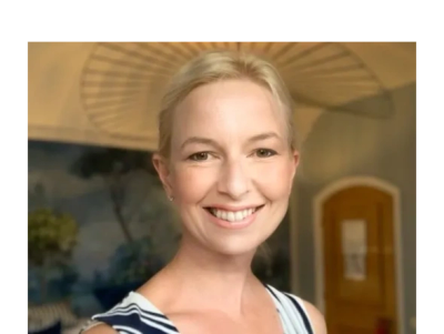Smiling woman with blonde hair indoors.