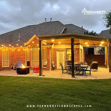 Attached patio cover with string lights over a fire pit and dining area