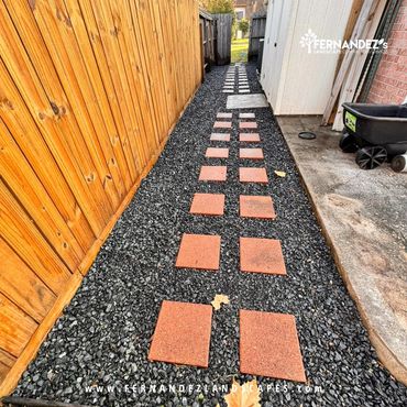 Side-yard path of terracotta pavers set in black gravel