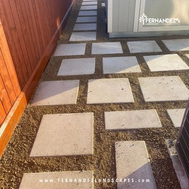 Large concrete squares with gravel joints along a side yard