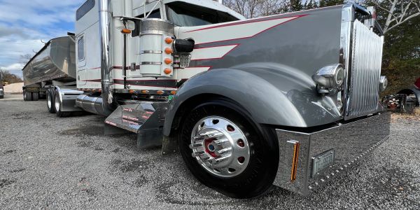 Close-up of a large gray semi-truck parked on gravel.