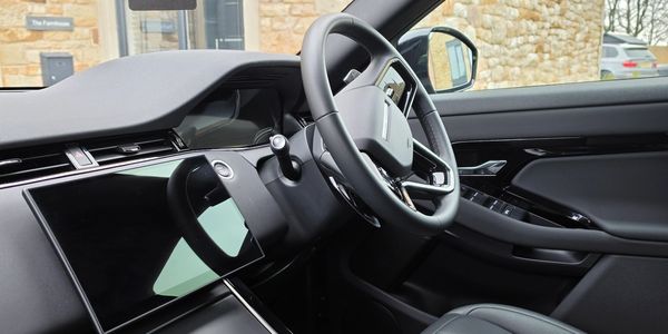 Interior of a modern car with a sleek dashboard and steering wheel after premium interior cleaning.