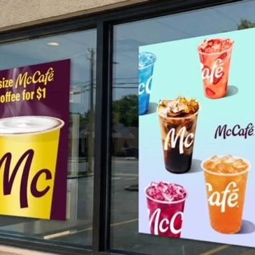 McCafé advertisement showcasing various iced drinks outside a coffee shop window.