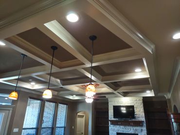 Cozy living room with coffered ceiling and warm pendant lights.