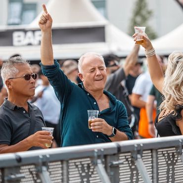 People enjoying drinks and dancing at an outdoor event.