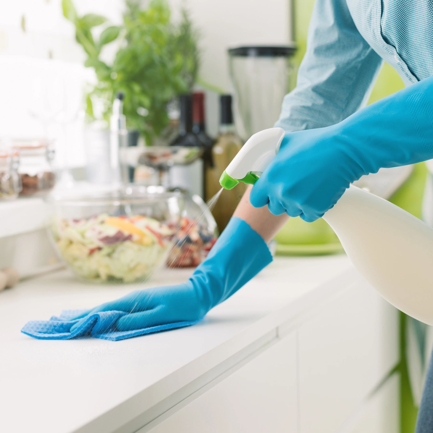 A person cleaning a kitchen countertop