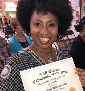 Rev. Karen holding a certificate from the Beacon Newspaper. Her poem, "Colin Couldn't Stand," earned an Honorable Mention from the Beacon during its inaugural arts contest.