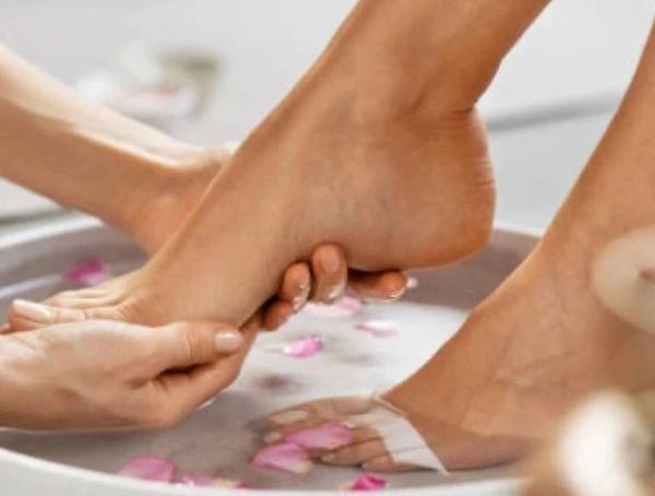 Foot massage with flower petal water soak.