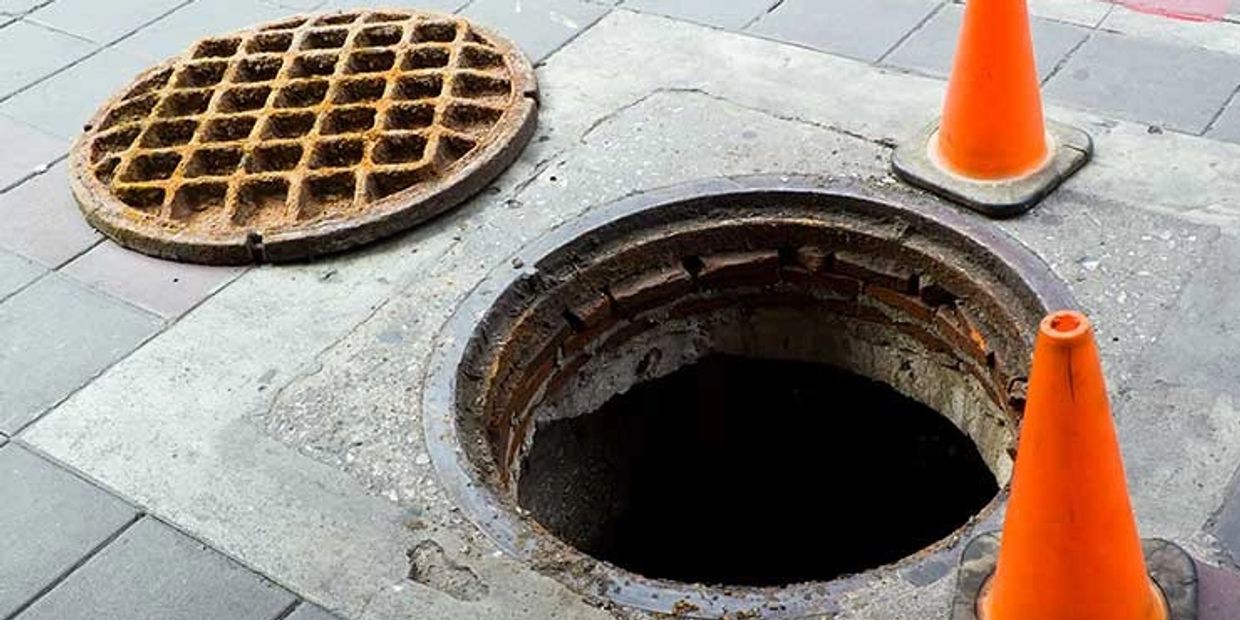 Open manhole cover on a street