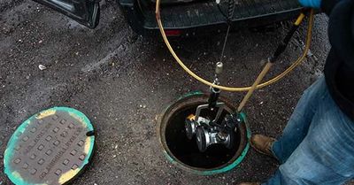 Worker inspecting a manhole