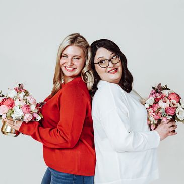 Lead and assistant wedding coordinators holding flower centerpieces