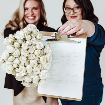 Lead and assistant coordinators holding wedding timeline and flower bouquet