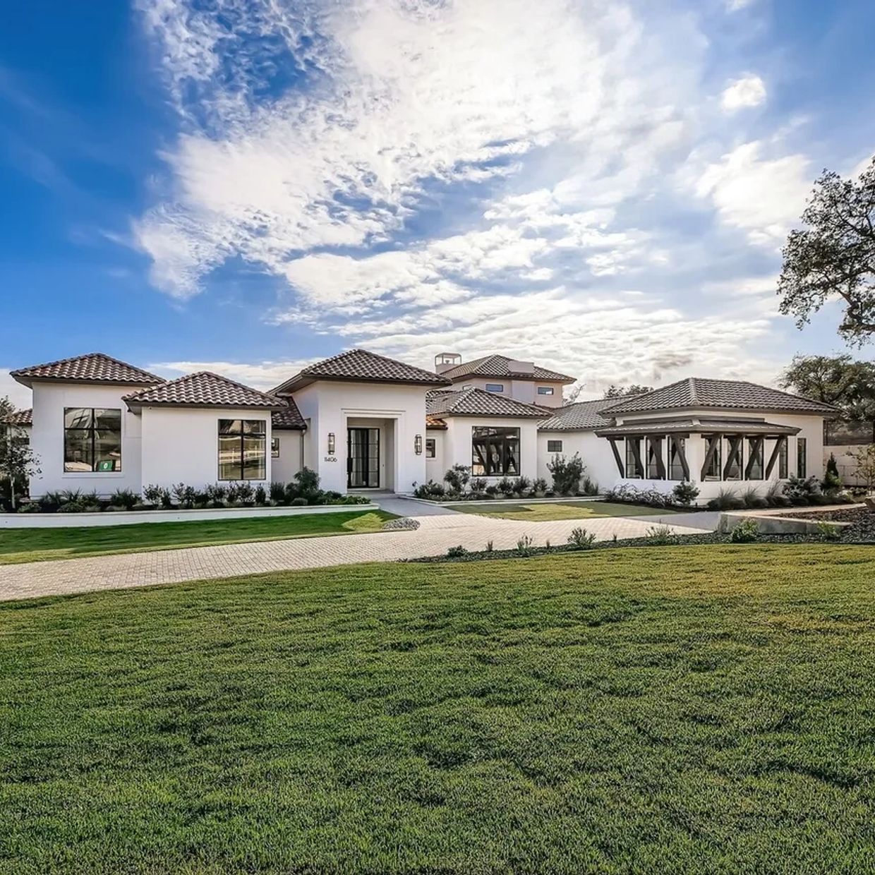 Modern large white house with tiled roof.