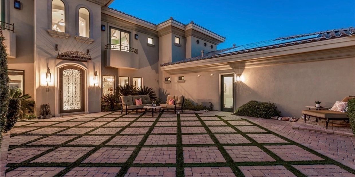 Elegant courtyard with grid-patterned stone tiles and cozy seating areas at dusk.
