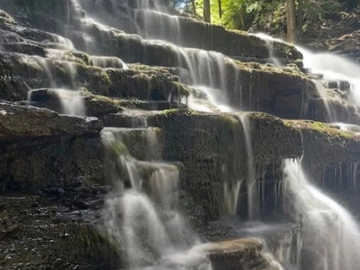 Multi-tiered waterfall cascading over rock formations.