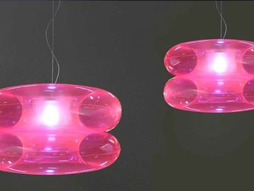 Two pink modern pendant lights glowing against a dark background.