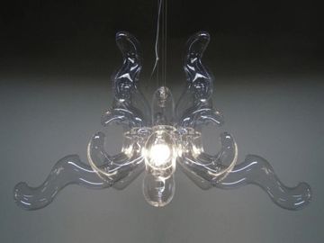 Modern clear glass chandelier with artistic curved arms and central light bulb.