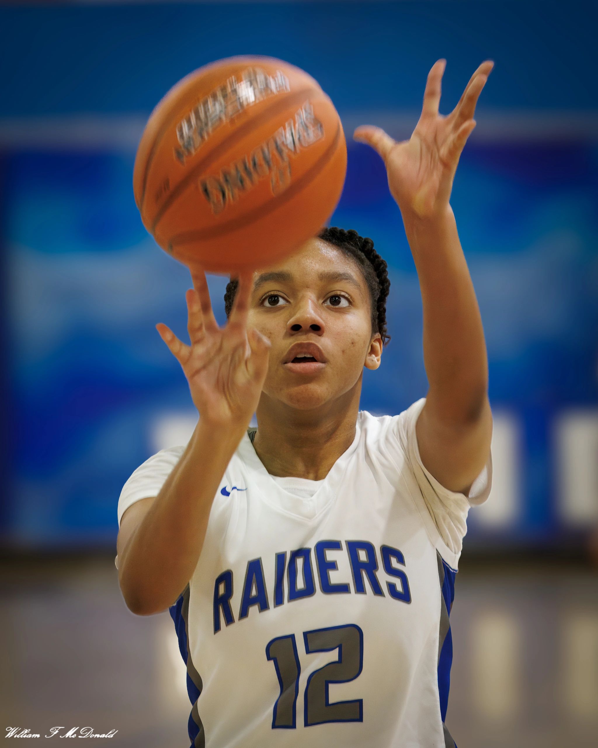 Focused basketball player shooting a free throw in a Raiders jersey.