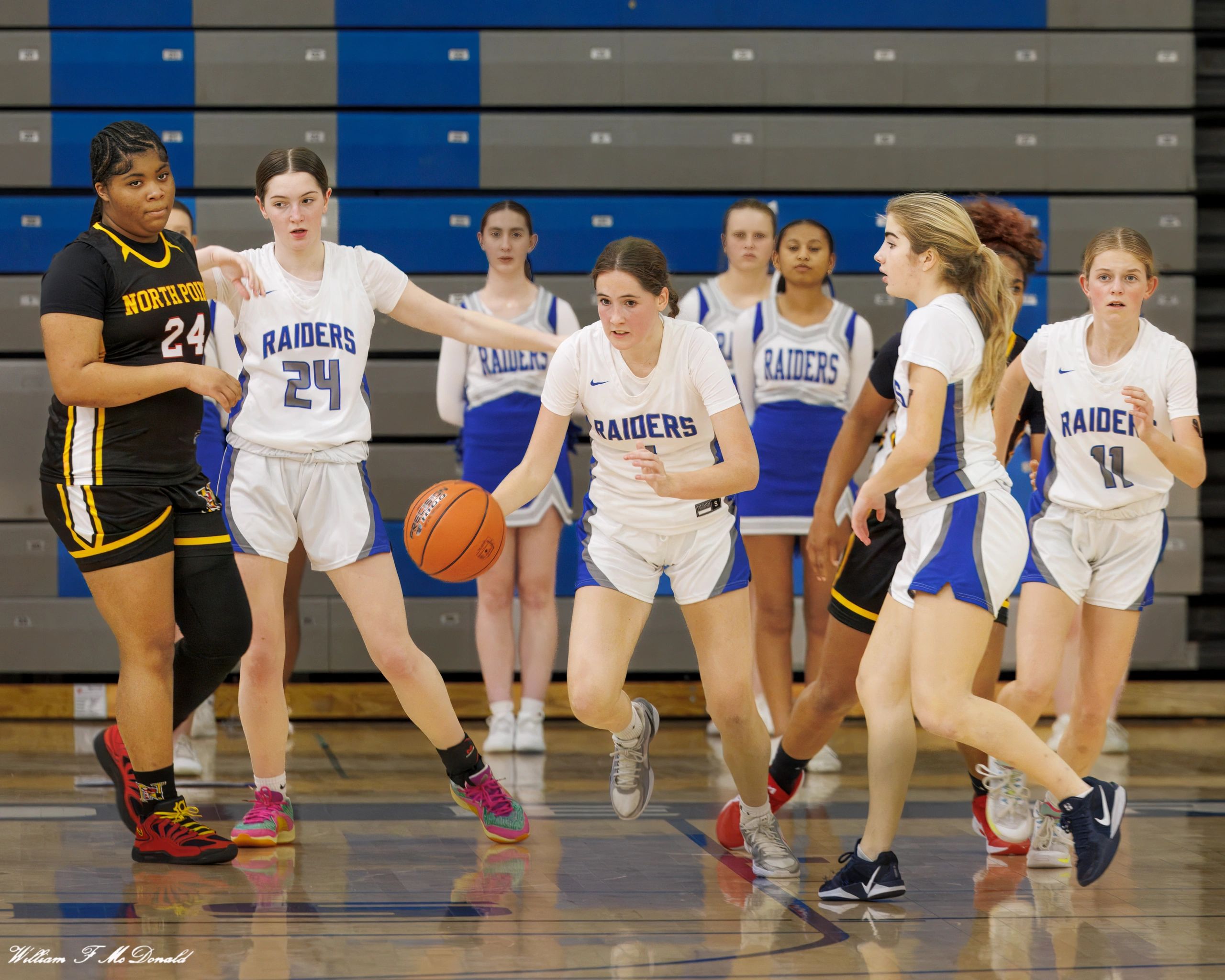 High school girls basketball game with Raiders and North Point teams in action.
