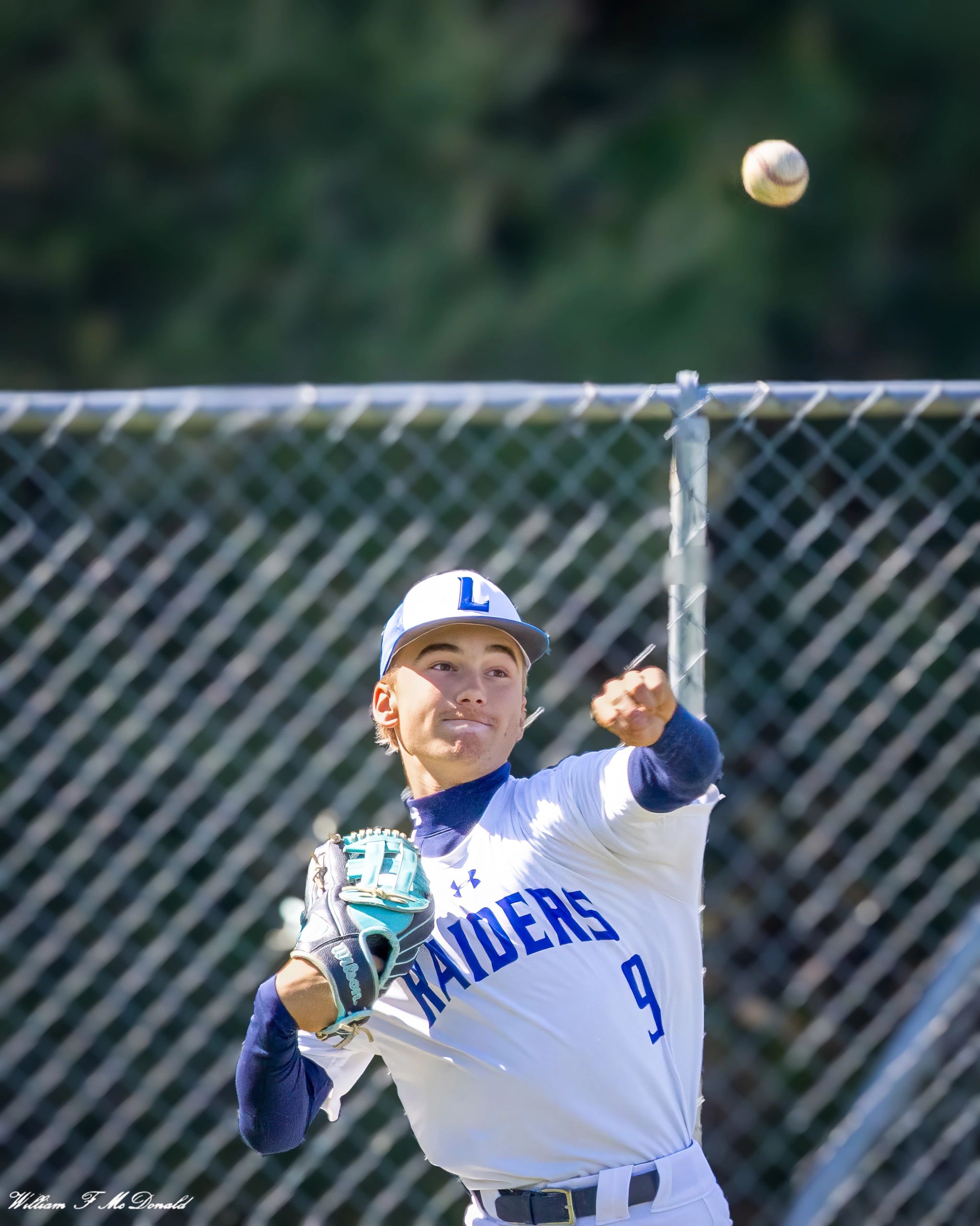 Baseball pitcher in action throwing a ball during a game.