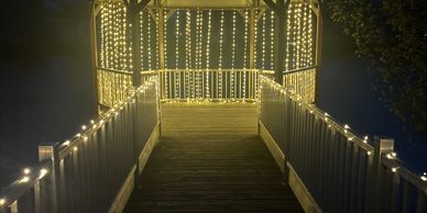 A gazebo beautifully lit with string lights at night.