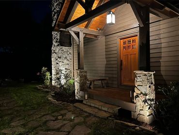 Front porch with landscape and security lighting installed at night