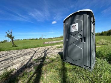 Portapotty in a field, ready for runners.