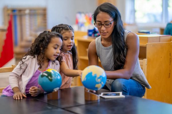 Woman and children studying globes