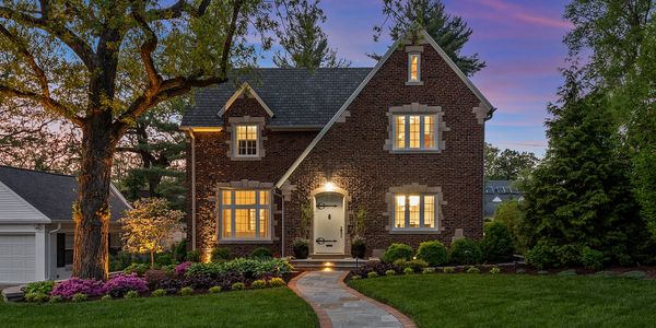 The front of a cottage style house at twilight