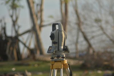 A surveying instrument mounted on a tripod outdoors.