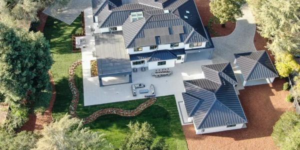 Aerial view of a modern house with a large patio and garden.