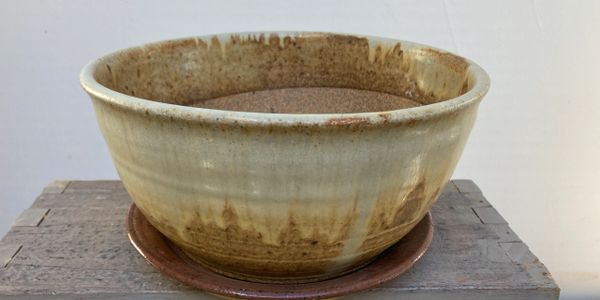 A rustic ceramic bowl with earthy glaze on a wooden surface.