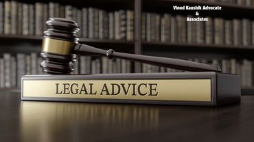 Wooden gavel and plaque labeled 'LEGAL ADVICE' on a desk with law books in background.