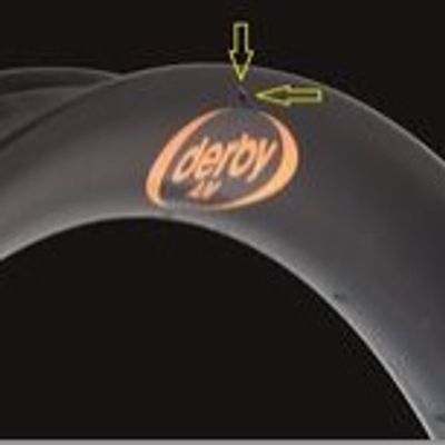Two yellow arrows pointing at the hole on top of derby logo