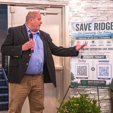 Man giving a speech at a Save Ridge donation event.