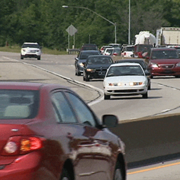 Busy highway with multiple cars driving in both directions.