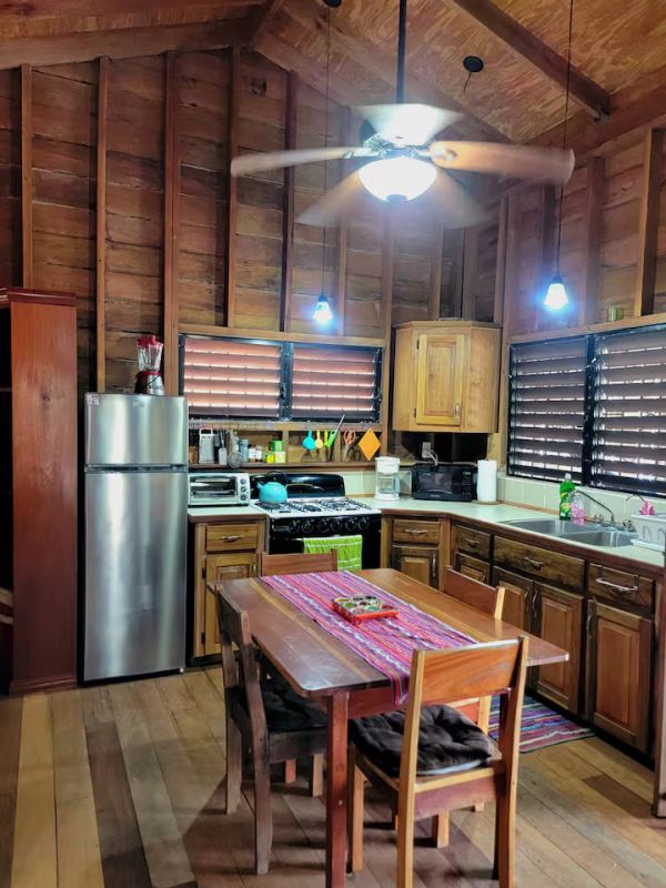 Rustic wooden kitchen with modern appliances and a dining table.