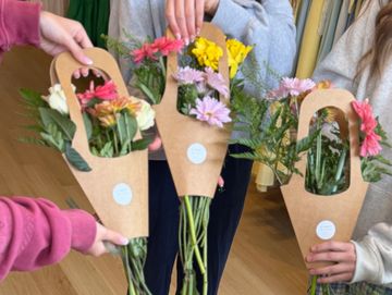 Three people holding flower bouquets at Bobble & Lace’s Flower Bar Event!