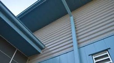 Close-up of a building's roof and siding with a gutter system.