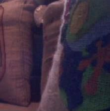 Close-up of a cushioned chair and part of a colorful pillow.
