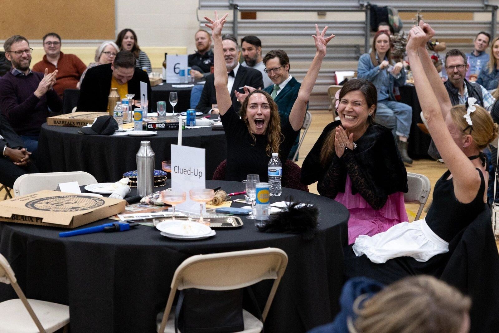 People celebrating at a social gathering around tables.