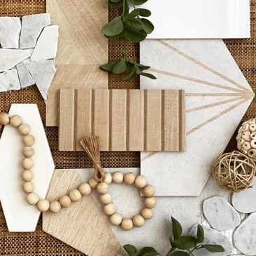 Flat lay of wood and stone tile samples with wooden beads and greenery.  Home design inspiration.