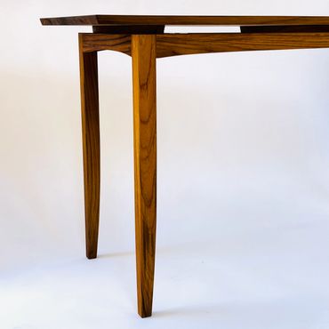 Elegant wooden table leg with unique design.