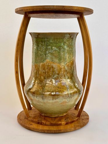 A ceramic vase in a wooden frame stand.